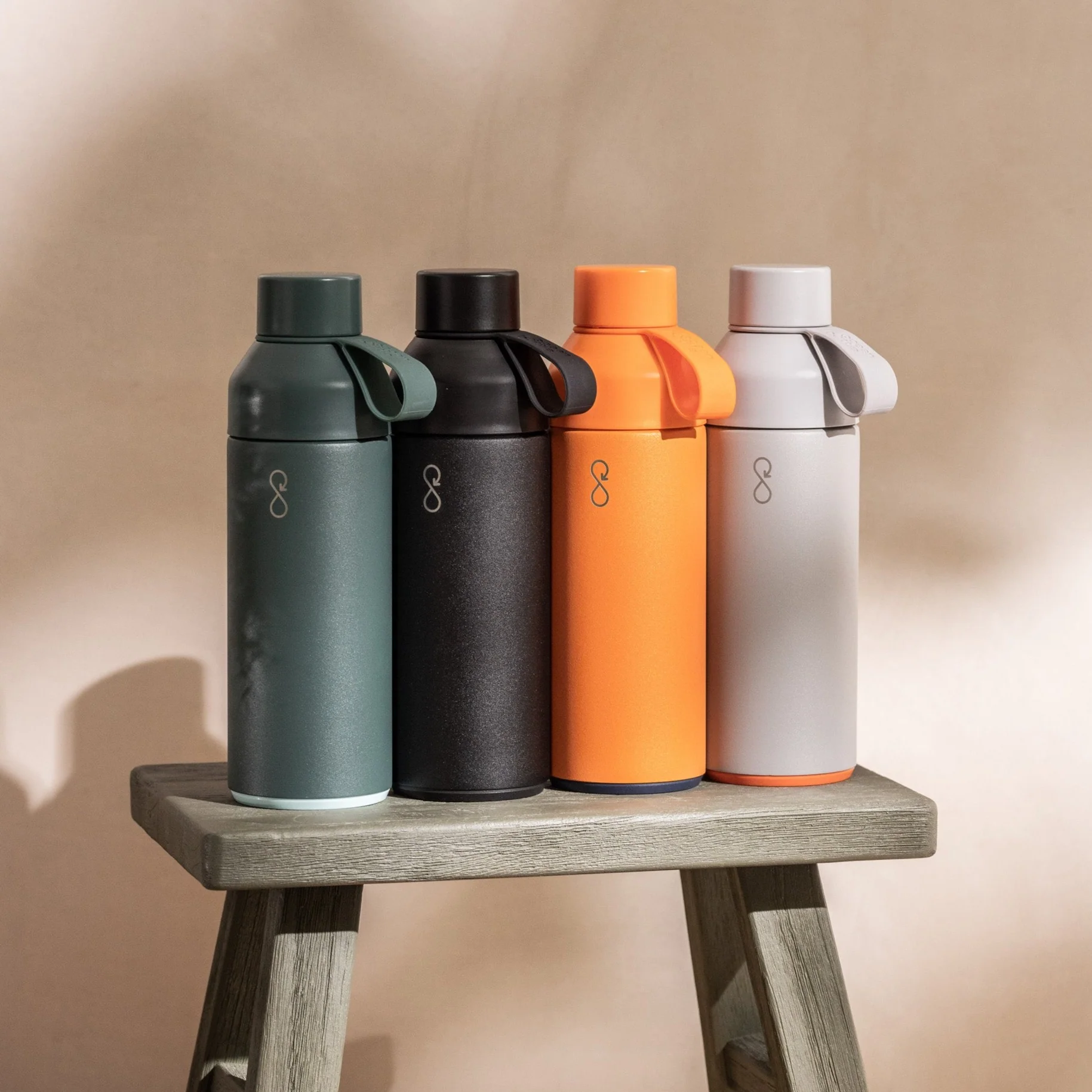 A group of different coloured Ocean Bottles on a stool